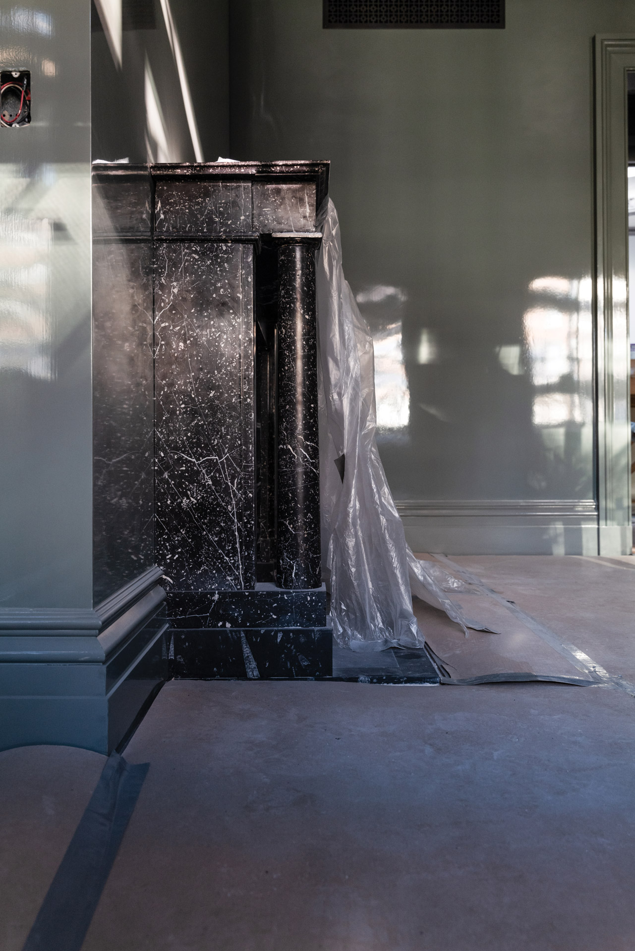 A mantelpiece of Black Kilkenny marble in a guest room.