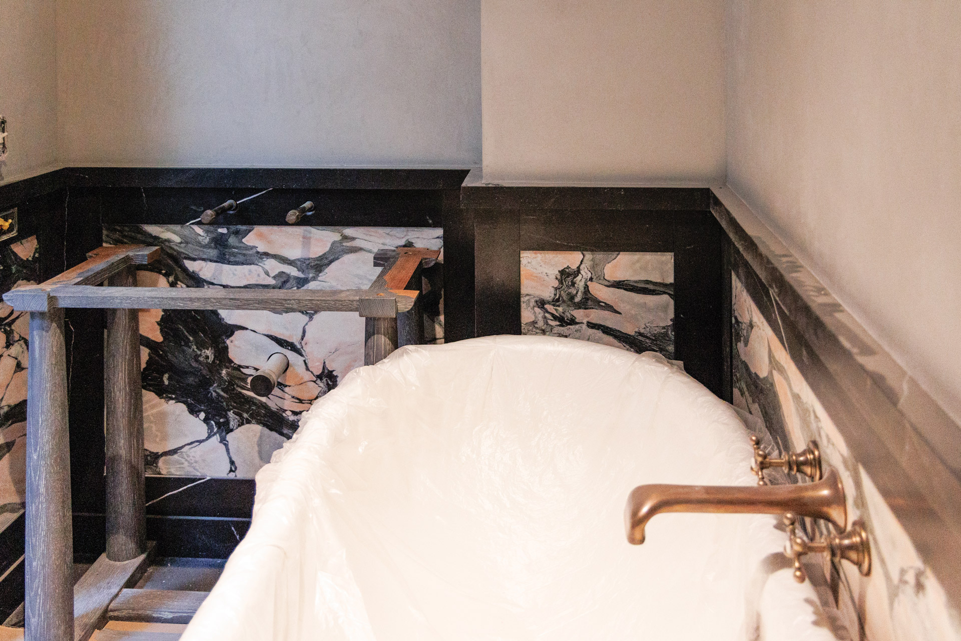 A striking composition in Black Venato marble and Midnight Rose marble in a guest bathroom.